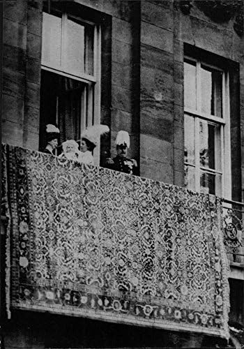 תצלום וינטג 'של המלכה ג'וליאן מחזיקה ילד בחוץ במרפסת.